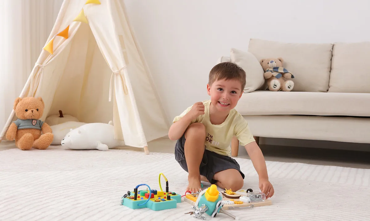 Smiling toddler playing with wooden Jumble Dream sensory toys on the floor